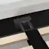Close-up of a bed frame showing a black metal support bracket attached to light wooden slats and secured to the upholstered bed base with screws. A black fabric strap is also visible across the slats.