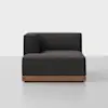 A modern, dark gray upholstered corner sofa with a low wooden base, shown against a plain white background.