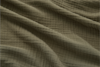 A close-up of olive green, crinkled fabric with visible texture and gentle folds running diagonally across the surface.