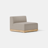 A modern armless lounge chair with light gray upholstery and a light wooden base, placed on a smooth, light-colored floor against a plain white background.