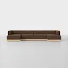 A modern, modular brown sectional sofa with wooden bases sits on a plain white floor against a white background. The sofa has clean lines and seats five or more people.