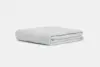 A neatly folded, light gray quilted blanket is shown against a plain white background. The blanket has a soft, smooth texture and visible stitched square patterns.