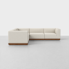 A modern L-shaped sectional sofa with light beige upholstery and a wooden base, set against a plain white background on a smooth, light gray floor.