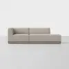 Modern light beige sectional sofa with a left armrest, low back, and wooden base, placed on a seamless, light gray floor against a plain white background.