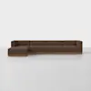 A modern sectional sofa with brown upholstery and a wooden base, featuring a left-facing chaise lounge, placed in a minimal, white room.