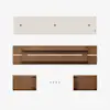 Top-down view of disassembled wooden furniture parts, including a long white panel, a long brown panel with a central opening, two smaller brown side pieces, and five black screws on a white background.