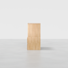 A minimalist light wood cabinet with clean lines, shown from the side against a plain white background on a smooth, light gray floor.