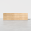 A minimalist, light wood dresser with six wide drawers, photographed against a plain white background on a smooth gray floor.