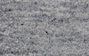 Close-up of a gray and white textured carpet showing looped fibers in a subtle mottled pattern. The surface appears soft and plush, with a mix of light and dark gray tones.