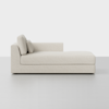 A modern, light beige chaise lounge with a left armrest and two back cushions is placed on a light gray floor against a plain white background.