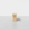 Minimalist wooden bench with clean lines, photographed from the front against a plain white background. The bench appears sturdy with a natural wood finish and casts a subtle shadow on the floor.