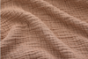 Close-up of textured, light brown fabric with wrinkled, crinkled surface and horizontal ridges creating a soft and cozy appearance.