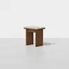 A minimalist wooden stool with a light cushioned seat, featuring a simple design and straight legs, placed on a plain white background.