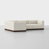 A modern, L-shaped sectional sofa with light beige upholstery and a dark wood base, set on a plain white background.