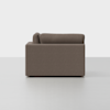 Side view of a modern, boxy brown fabric sofa with straight armrests and backrest cushions, placed on a light gray floor against a plain white background.
