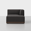 A modern, dark gray upholstered sectional sofa corner seat with clean lines and a low wooden base, set against a plain light gray background.