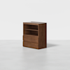 A wooden cabinet with a minimalist design, featuring open shelves on the top and two closed drawers at the bottom, set against a plain white background.