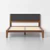 A modern wooden bed frame with a dark upholstered headboard, light-colored wooden slats, and clean, minimalist design, positioned against a plain white wall on a gray floor.