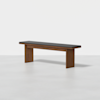 A minimalist wooden bench with a dark cushioned seat and rectangular legs, placed on a light gray surface against a plain white background.