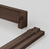 Two pieces of dark wood with interlocking joinery are positioned on a light surface, demonstrating how the ends fit together as part of a furniture assembly.