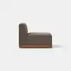 A modern armless brown upholstered chair with a wooden base, shown from the side against a plain white background and a light gray floor.