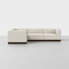 A modern, L-shaped sectional sofa with cream-colored upholstery and a dark wooden base, set against a plain white background on a light gray floor.