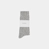 A single gray marled sock is neatly folded with a white label around it that reads “THUMA,” set against a plain white background.