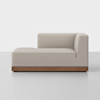 A modern lounge chair with light beige upholstery, a right-side backrest, and a low wooden base, set against a plain white background.
