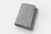 A neatly folded, rectangular gray knitted fabric or towel placed on a white background.