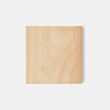A square piece of light-colored wood with visible grain patterns, photographed against a plain white background.