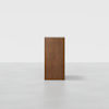 A wooden rectangular pedestal with a simple design stands upright on a light gray, seamless background.