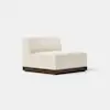 A modern armless chair with cream-colored upholstery and a dark wooden base, set against a plain light background.
