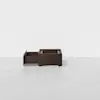 A dark wood storage box with one open drawer and a minimalist design, set against a plain white background.