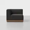 A modern, dark gray corner sofa with clean lines and a wooden base, set against a plain white background and placed on a light gray floor.