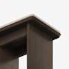 Close-up view of the corner of a dark wooden table or desk with a light-colored edge on the tabletop, set against a plain white background.