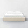A minimalist beige platform bed with white bedding and two pillows, set against a plain white wall and floor.