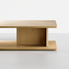 Minimalist wooden coffee table with a rectangular top and bottom shelf, connected by a vertical central panel, set against a plain white background.
