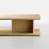 Minimalist wooden coffee table with a rectangular top and bottom shelf, connected by a vertical central panel, set against a plain white background.