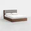 A modern wooden bed with a light gray upholstered headboard, neatly made with white bedding and two white pillows, set against a plain white background.