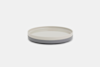 A round, shallow plate with a white interior and a gray exterior, displayed against a plain white background.
