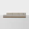A modern sectional sofa with light beige upholstery and a wooden base, consisting of three connected seats including a left chaise and a right armrest, set against a plain white background.