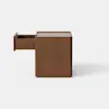 A simple, square wooden box with smooth edges sits on a light gray surface against a plain white background.