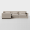 A modern, light beige sectional sofa with three seat cushions and three back cushions, featuring clean lines and low arms, set against a plain white background.