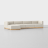 A modern sectional sofa with light beige upholstery and a low wooden base, arranged in an L-shape on a plain light gray floor, against a clean white background.