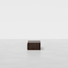 A minimalist image shows a single, dark brown rectangular table set against a plain white background with ample empty space around it.