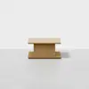 A minimalist, rectangular wooden coffee table with a thick central support and flat base, set against a plain white background.