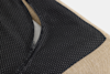 Close-up of a zippered black fabric with small white dots, partially open to reveal a beige textured material underneath. The photo focuses on the textures and patterns of the fabrics.