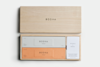 A wooden box with “BODHA” on the lid contains two rectangular incense packages, one gray labeled “Calm” and one orange labeled “Ground,” along with a white card titled “Rituals by Bodha.”.