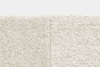 Close-up of two different cream-colored carpet textures side by side; the left side is smoother and more velvety, while the right side has a looped, more textured surface.
