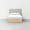 A modern wooden bed frame with a light gray upholstered headboard and white bedding, positioned against a plain white wall on a gray floor.